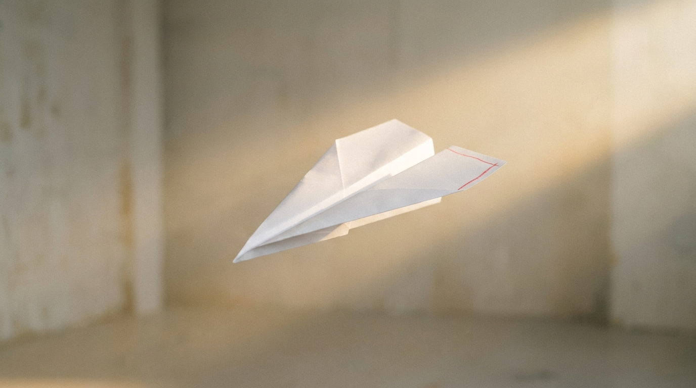 A pristine paper aeroplane in confident flight lifted on a shaft of light with a red wingtip, illustrating working backwards from an imagined future win